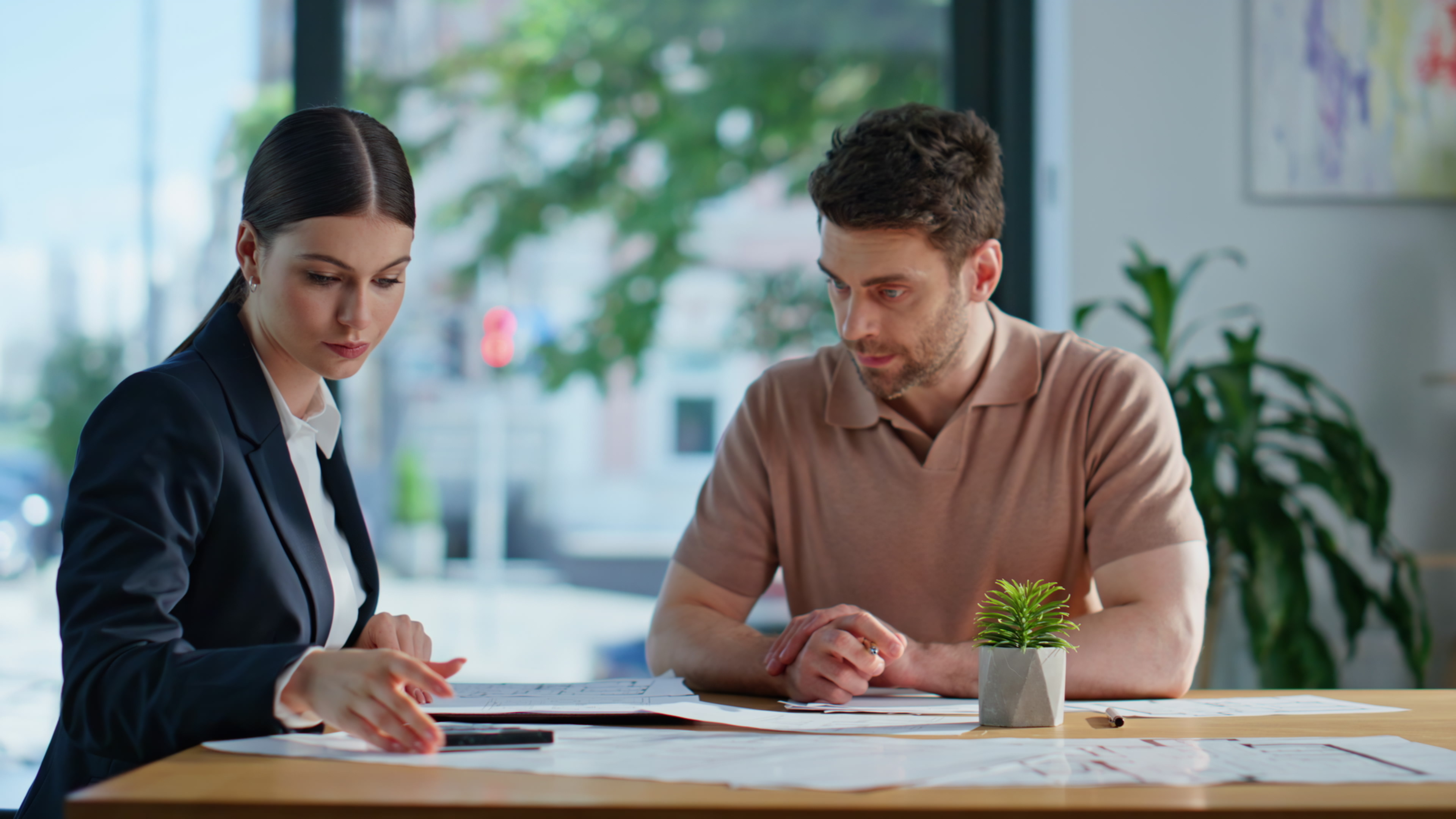 Professional advisor reviewing workforce planning documentation with a client in a modern office environment
